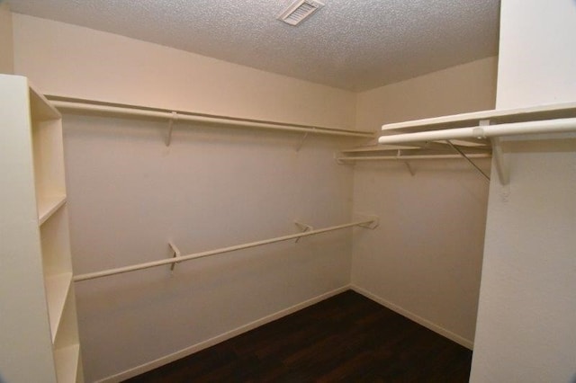 spacious closet featuring wood finished floors and visible vents