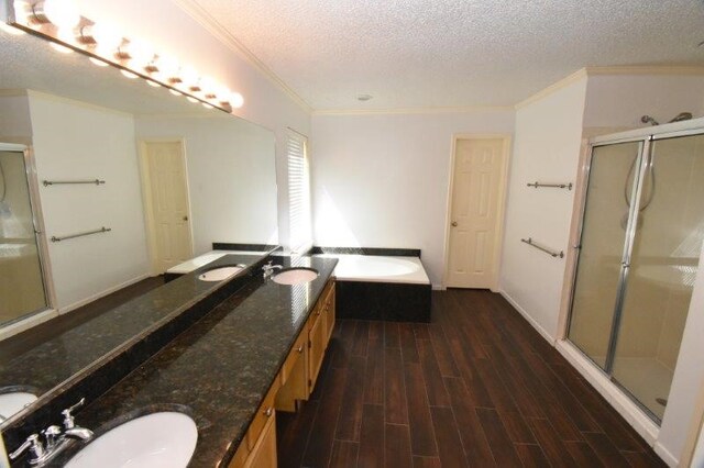 full bathroom with a shower stall, ornamental molding, wood finished floors, a textured ceiling, and a sink