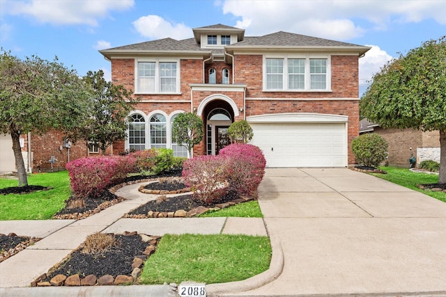 view of front of house featuring brick siding, an attached garage, concrete driveway, and a front lawn