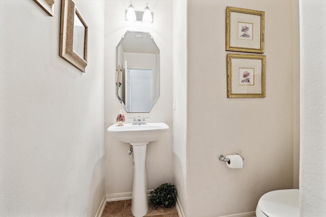 bathroom with tile patterned floors, toilet, and baseboards