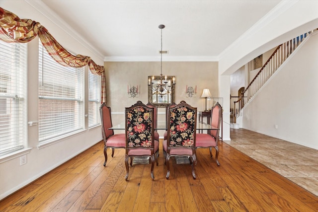 dining space featuring an inviting chandelier, stairway, wood-type flooring, and ornamental molding