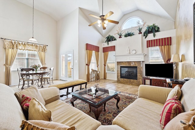 living room featuring a tiled fireplace, a wealth of natural light, and high vaulted ceiling