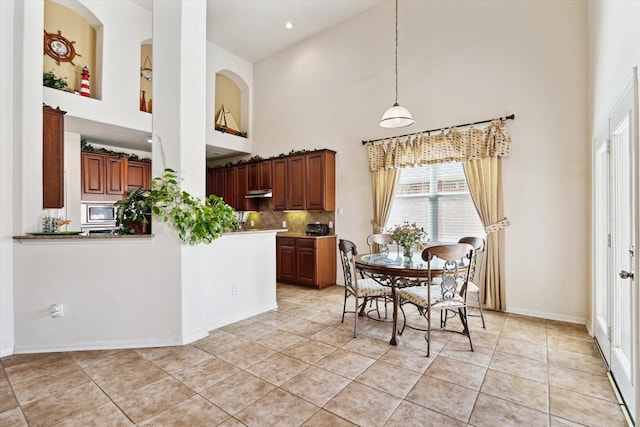 dining area featuring light tile patterned floors, recessed lighting, baseboards, and a towering ceiling