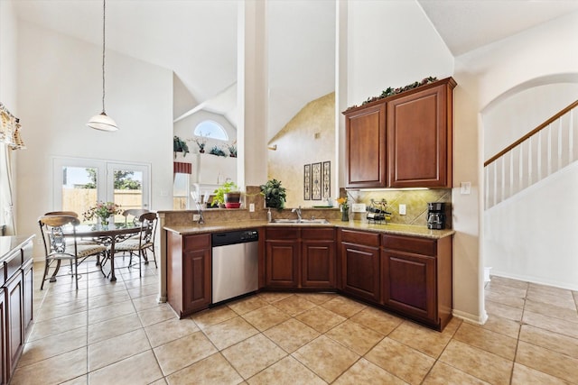 kitchen featuring high vaulted ceiling, a sink, tasteful backsplash, stainless steel dishwasher, and light tile patterned floors