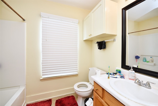 bathroom with toilet, vanity,  shower combination, and baseboards