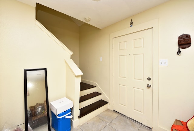 entryway with light tile patterned floors and stairs