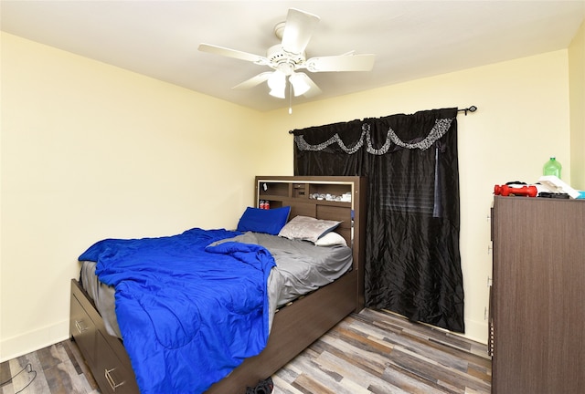 bedroom featuring baseboards, ceiling fan, and wood finished floors