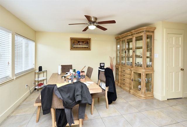 dining area featuring baseboards, light tile patterned flooring, and a ceiling fan