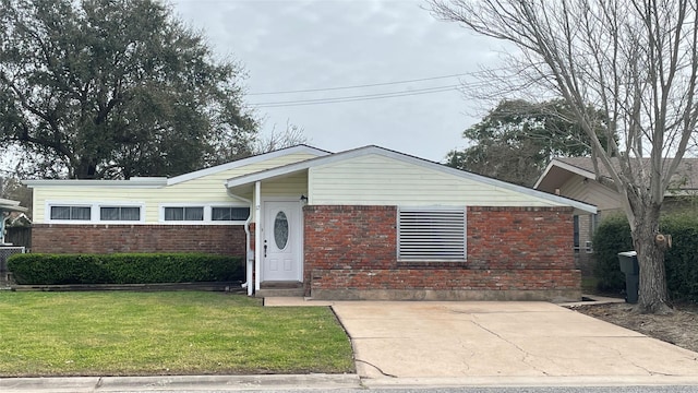 view of front facade with brick siding and a front lawn