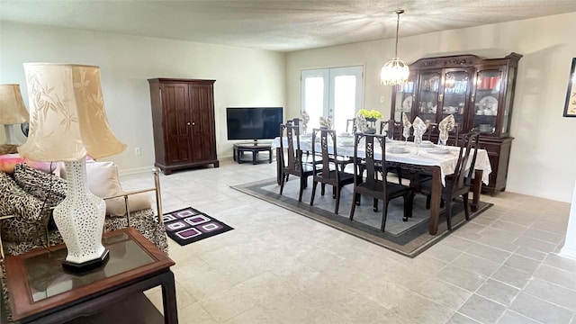 dining room with a notable chandelier and french doors