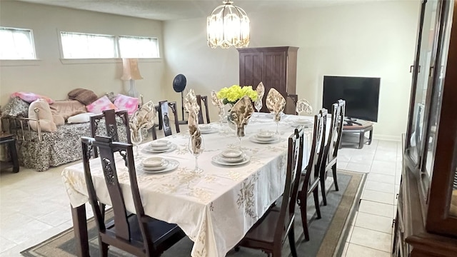 dining room featuring a notable chandelier, baseboards, and light tile patterned floors