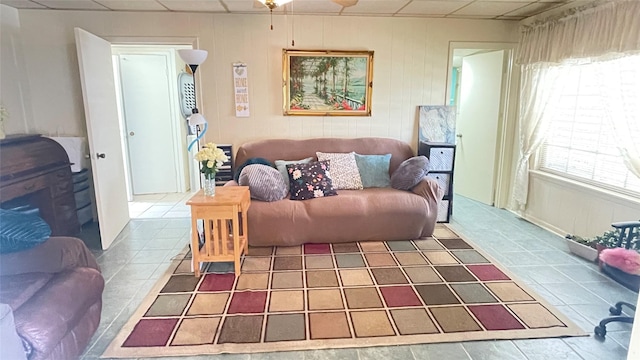 tiled living room featuring a drop ceiling