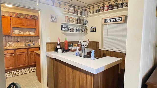 bar with a sink, bar area, tasteful backsplash, and light floors