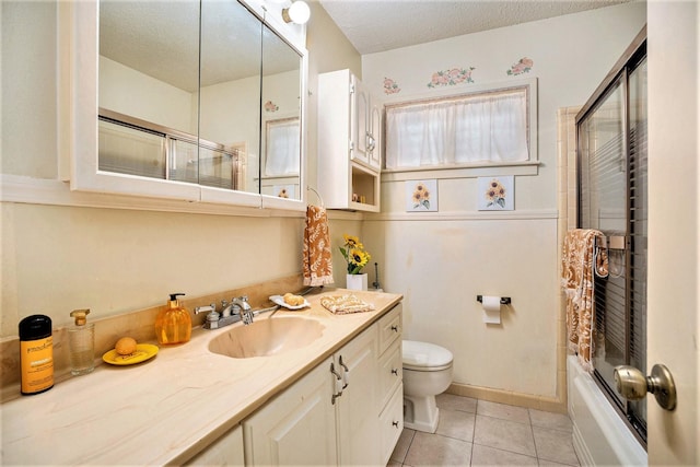 bathroom featuring tile patterned floors, a textured ceiling, toilet, and vanity