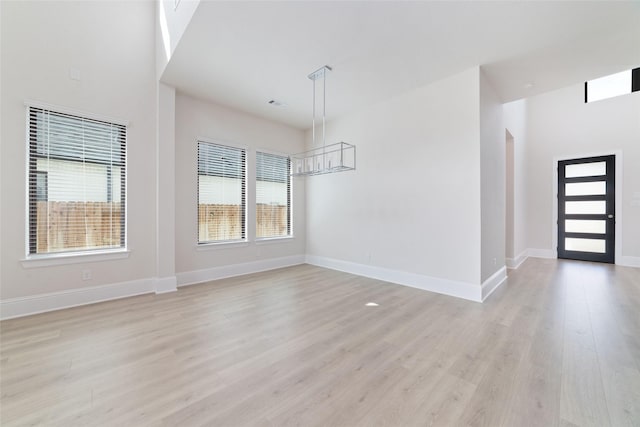 unfurnished dining area with visible vents, baseboards, and light wood-style floors