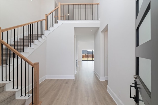 interior space featuring a high ceiling, wood finished floors, and baseboards