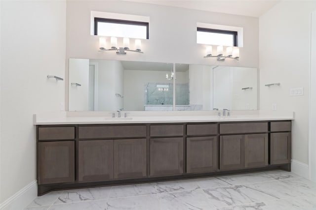 full bath featuring double vanity, walk in shower, marble finish floor, and a sink