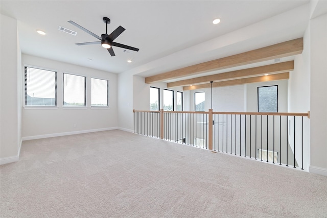 empty room with visible vents, beamed ceiling, baseboards, and a healthy amount of sunlight