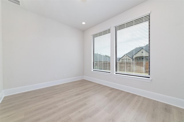 unfurnished room with visible vents, recessed lighting, light wood-type flooring, and baseboards