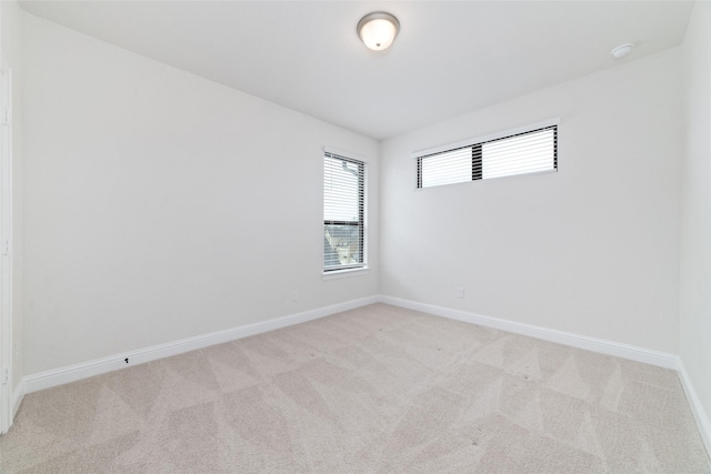 empty room featuring baseboards and carpet flooring