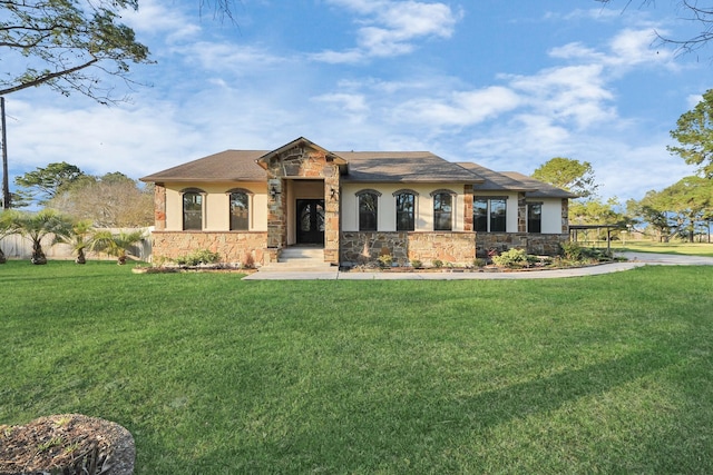 view of front facade with stucco siding, stone siding, and a front yard