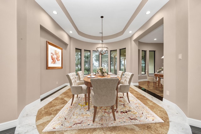 dining area with recessed lighting, baseboards, a raised ceiling, and an inviting chandelier