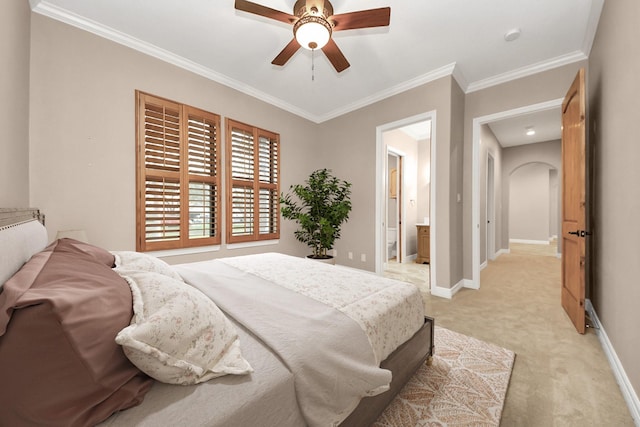 bedroom with a ceiling fan, baseboards, ornamental molding, ensuite bathroom, and light colored carpet