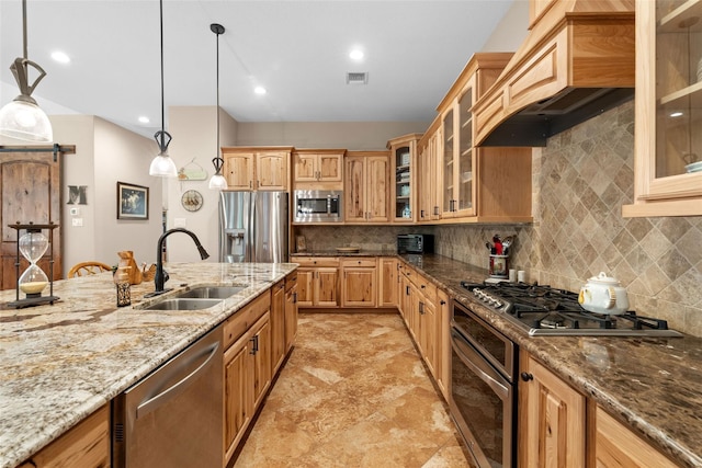 kitchen with premium range hood, visible vents, a sink, stainless steel appliances, and a barn door