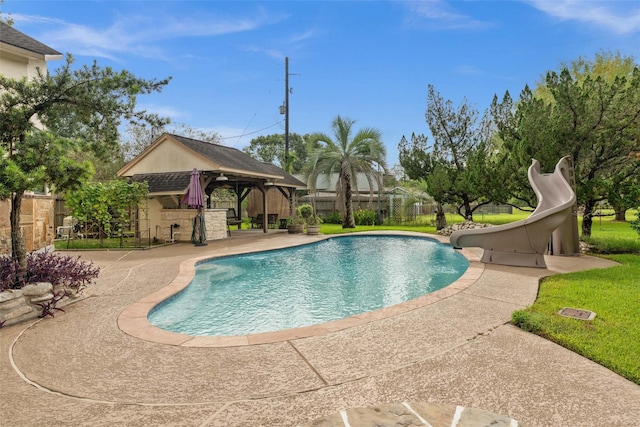 view of swimming pool featuring an exterior structure, a fenced in pool, a water slide, a fenced backyard, and a patio