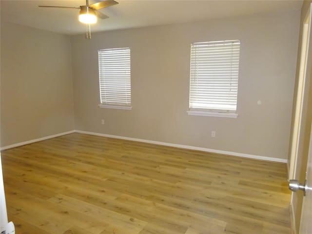 unfurnished room with light wood-type flooring, baseboards, and a ceiling fan