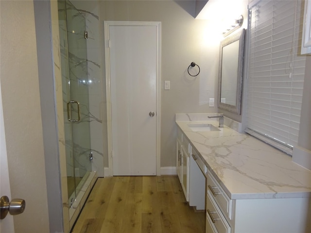 full bathroom featuring vanity, wood finished floors, and a marble finish shower