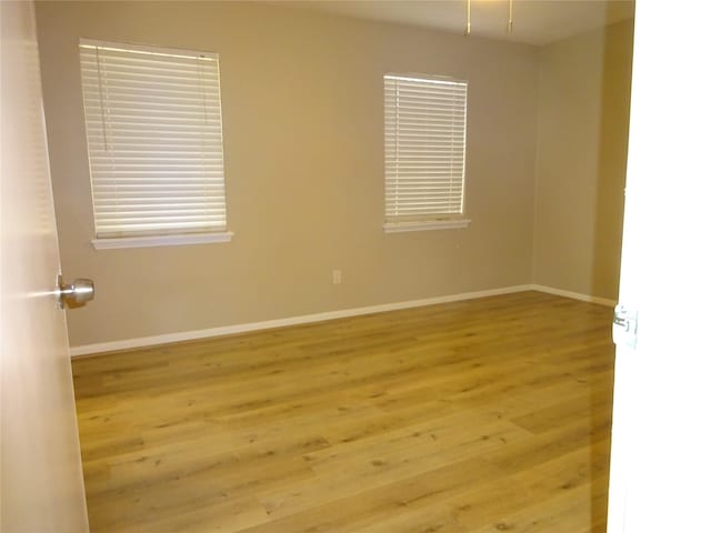 unfurnished room featuring baseboards and wood finished floors