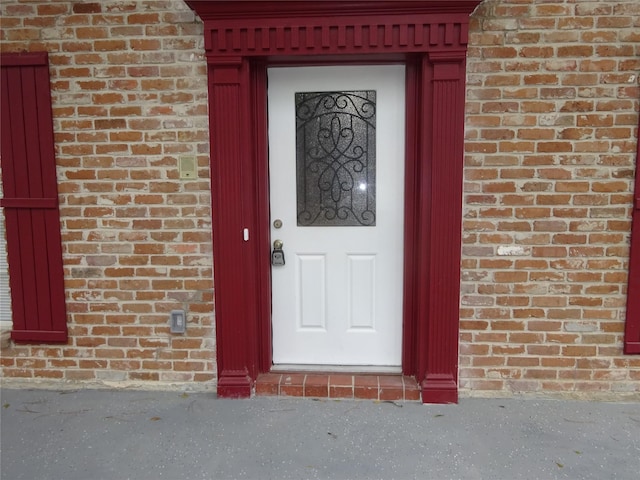 view of exterior entry with brick siding