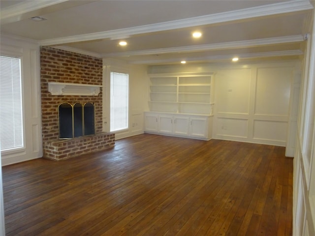 unfurnished living room featuring beamed ceiling, ornamental molding, a fireplace, dark wood-style floors, and a decorative wall