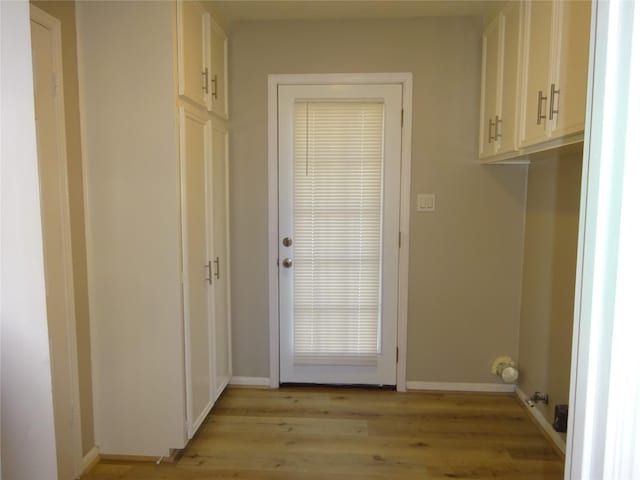 doorway to outside featuring light wood-style flooring and baseboards