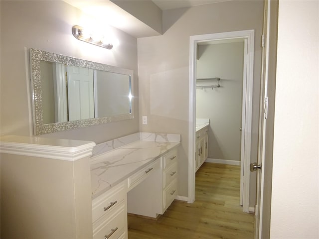 bathroom with vanity, baseboards, and wood finished floors