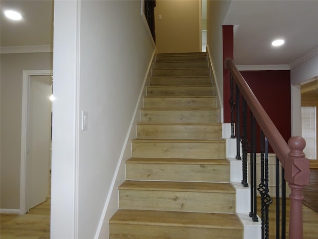 stairs with wood finished floors, recessed lighting, baseboards, and ornamental molding