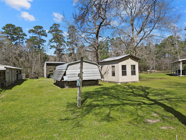 view of yard with a carport and an outbuilding