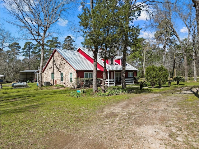 view of front of home featuring metal roof, central AC, and a front lawn