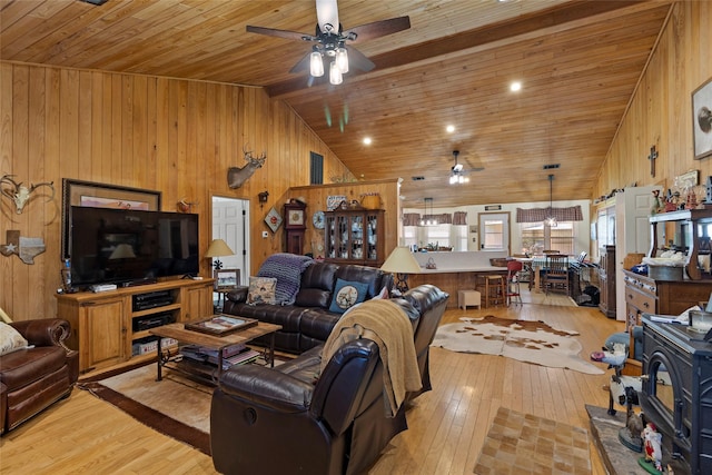 living area with wood walls, light wood-type flooring, and a ceiling fan