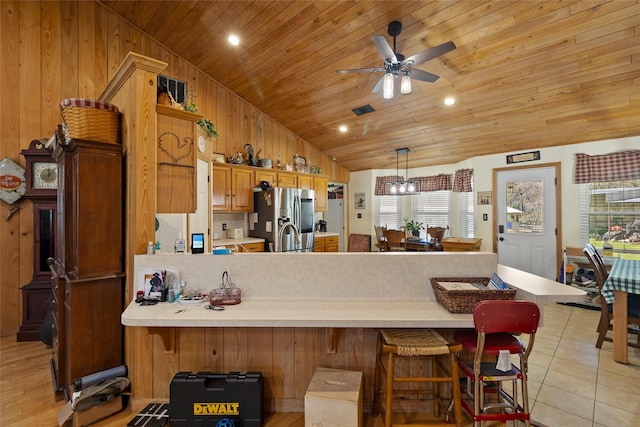 kitchen featuring stainless steel refrigerator with ice dispenser, a peninsula, wooden ceiling, light tile patterned flooring, and light countertops