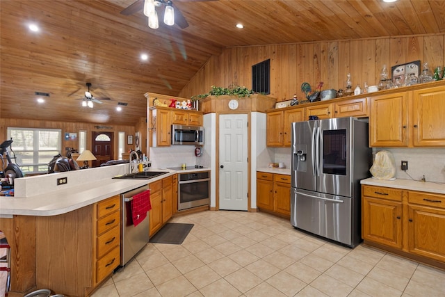 kitchen featuring light tile patterned floors, a peninsula, stainless steel appliances, light countertops, and backsplash