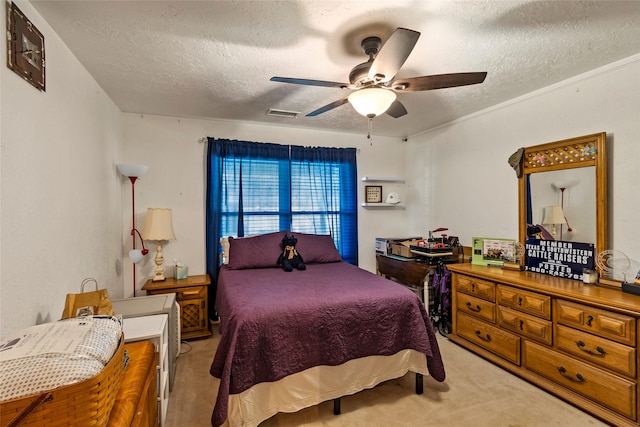 bedroom with a textured ceiling, a ceiling fan, visible vents, and light carpet