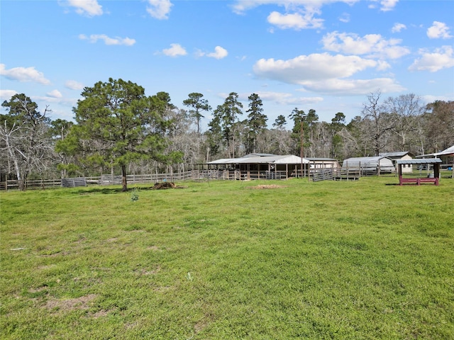 view of community featuring an exterior structure, an outdoor structure, and fence