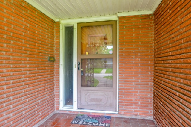 doorway to property with brick siding