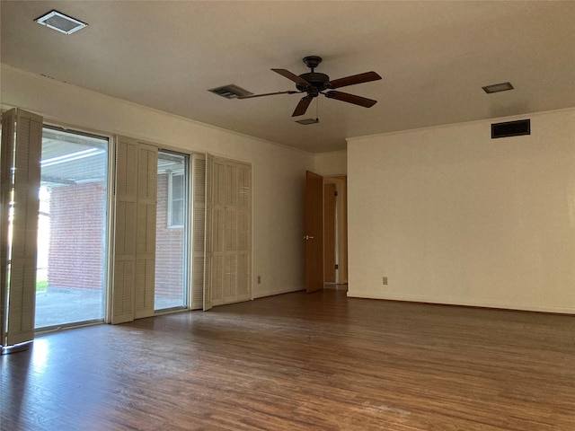 unfurnished room with ceiling fan, visible vents, baseboards, and wood finished floors