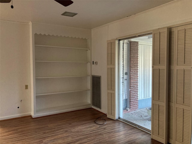 unfurnished bedroom with visible vents, baseboards, ornamental molding, wood finished floors, and access to outside