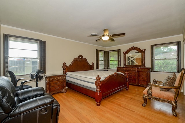 bedroom with ceiling fan, crown molding, and light wood finished floors