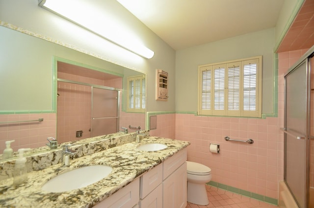 full bath featuring tile patterned flooring, toilet, tile walls, and a sink