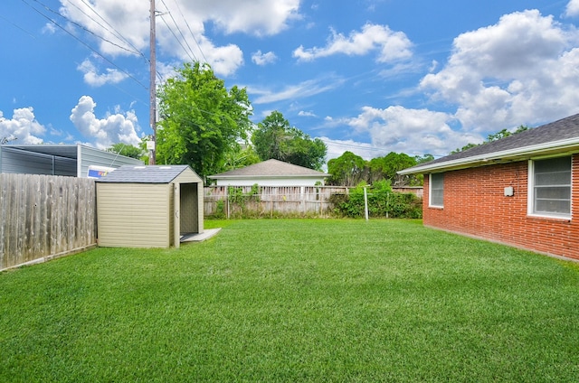 view of yard featuring a fenced backyard, a storage unit, and an outdoor structure